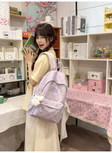 Detail showing purple leisure backpack with heart pattern and cute plush charm on a model