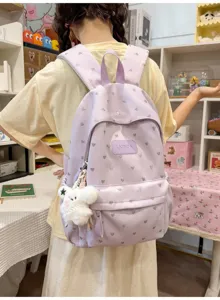 Detailed back view of a lightweight purple heart-print backpack on a casual student model