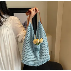 Detail of light blue hollow crochet knit shoulder bag with yellow tulip decoration