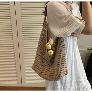 Detailed shot of a stylish khaki hollow knit shoulder bag worn with a white dress.