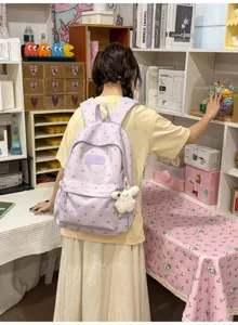 Detailed view of a lightweight purple heart-patterned student backpack worn by a model