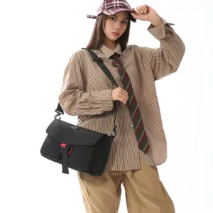 Bolso bandolera funcional techwear negro con detalle rojo llevado por una modelo femenina