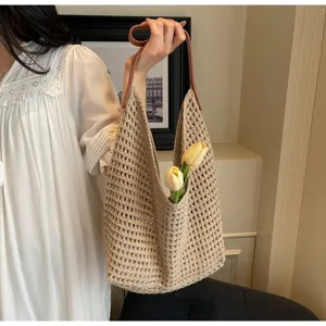 Lifestyle view of a beige hollow knit woven shoulder bag with tulips