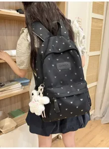 Black casual backpack with heart print shown worn by a student in a cozy room