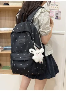 Black casual backpack featuring silver heart patterns and a cute white plush bunny keychain