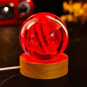 Detailed macro view of 3D engraved crystal ball night light with vibrant red glow