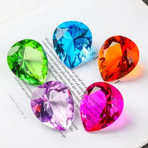 Close-up of five colorful pear-shaped faceted crystal gemstones on a book page