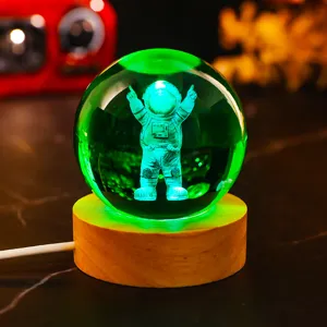 Detail view of 3D laser engraved astronaut crystal ball with green LED light on wooden base