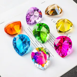 Colorful teardrop faceted crystal diamonds arranged on an open white magazine page