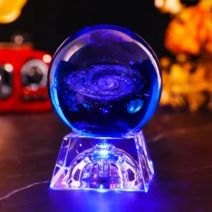Close-up of 3D galaxy laser engraved crystal ball with blue LED base light