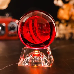 Close-up of a 3D laser engraved crystal ball night light with warm red lighting