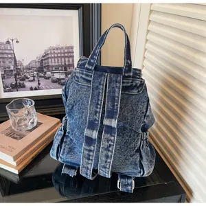 Detailed back view of a vintage denim backpack with adjustable wide shoulder straps