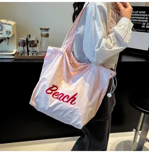 Bolso tote grande rosa informal con bordado Beach rojo usado por una modelo