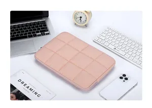 Primo piano di una custodia per laptop rosa trapuntata su una scrivania moderna