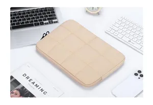 Dettaglio custodia porta PC beige trapuntata su scrivania da ufficio
