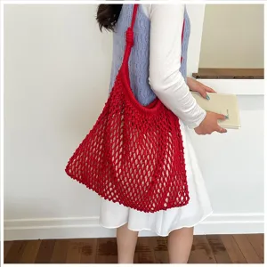 Vue détaillée du sac en filet creux tissé rouge porté par un mannequin