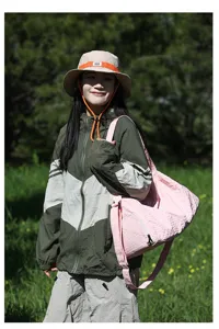 Détail du sac de voyage rose en tissu Oxford porté par un mannequin en extérieur