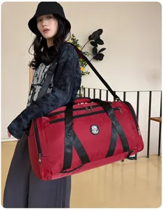 Grand sac de sport et de voyage rouge porté par un mannequin en tenue décontractée