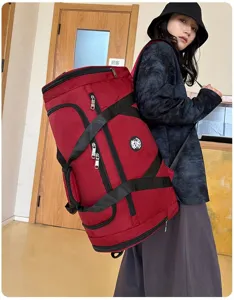 Femme portant un grand sac de sport rouge montrant la taille et les sangles polyvalentes
