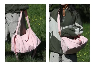 Vue détaillée d'un grand sac de voyage rose texturé porté dans un champ d'herbe extérieur