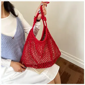 Détail d'un sac cabas en maille tressée rouge fait main pour un look de vacances à la plage