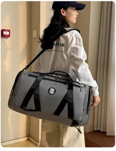 Gros plan montrant les détails d'un grand sac de sport gris porté par un mannequin à l'intérieur.
