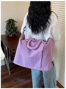 Large purple expandable travel bag for gym and weekend trips being carried by a model