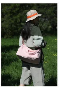Modèle portant un sac bandoulière rose en tissu Oxford de grande capacité en extérieur.