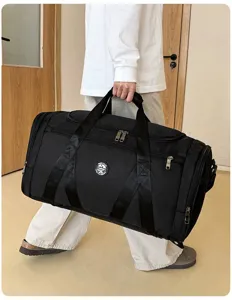Grand sac de sport noir porté à la main montrant sa taille dans un cadre de vie réel
