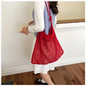 Femme portant un sac cabas en maille rouge pour les vacances et les voyages d'été