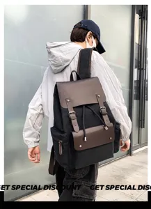 Detalle de una mochila vintage de lona negra con detalles en cuero marrón en modelo