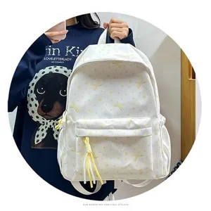 Vista detallada de una linda mochila blanca con patrones de lazos amarillos