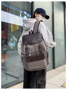 Mochila retro de lona con solapa de cuero marrón usada en entorno urbano