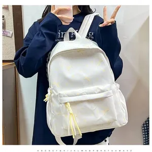 Primer plano de una mochila escolar blanca de estilo coreano con detalles amarillos