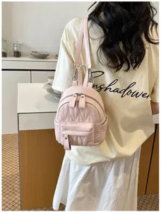 Hippe roze mini-rugzak voor dames met een gewatteerd ontwerp in een indoor lifestyle-omgeving