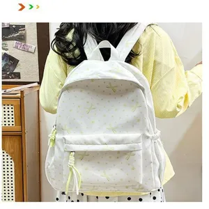 Vista detallada de una mochila blanca con diseño de lazos llevada por un estudiante