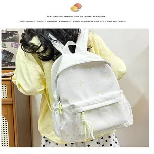 Vista trasera de un estudiante con mochila blanca de estilo coreano y motivos amarillos