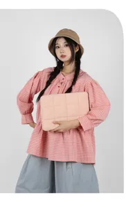 Modella asiatica con una custodia rosa trapuntata per laptop e tablet