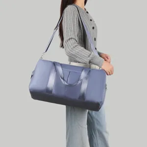 Detailansicht einer großen blauen wasserdichten Reisetasche, die von einem Modell getragen wird