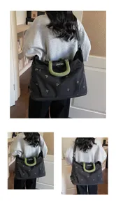 Multiple views of a large black travel bag with green handles worn by a model