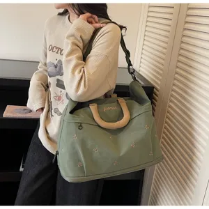 Close-up of a stylish olive green large capacity travel bag with bow embroidery motifs