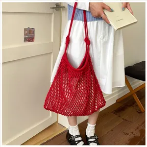 Détail d'un grand sac cabas rouge tissé en maille pour les vacances à la plage et voyages