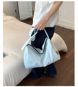 Detailansicht einer hellblauen Nylon-Umhängetasche im japanischen Stil von einem Model