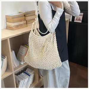 Sac cabas en macramé tissé à la main avec des détails de nœuds pour un look bohème.