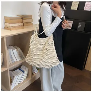 Photo de style de vie d'un grand sac fourre-tout en macramé crème porté par un mannequin élégant