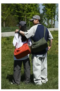 Photo de mode en plein air de modèles portant des sacs bandoulière en tissu Oxford.
