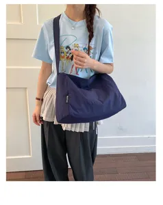 Marineblaue wasserfeste Nylon-Tragetasche mit großer Kapazität, am Modell für die Freizeit gezeigt