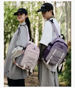 Vista de estilo de vida de dos modelos con mochilas de senderismo rosas y moradas en el bosque.