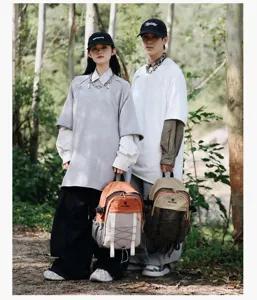 Vista detallada de dos modelos con mochilas de senderismo bicolor en el exterior
