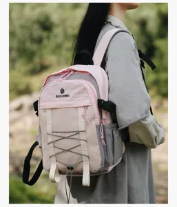 Modelo femenina con una mochila de senderismo ligera rosa y gris en exteriores